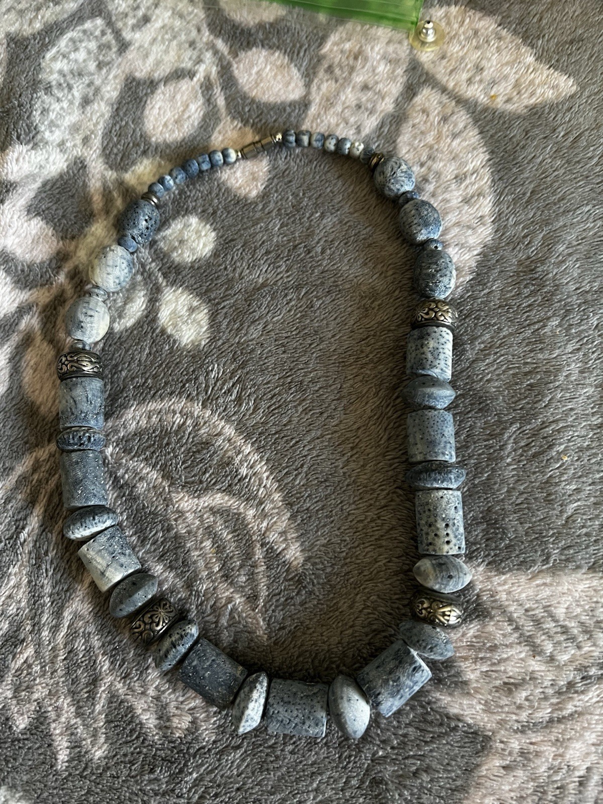 A contemporary necklace with blue coral-like beads and metal spacers.