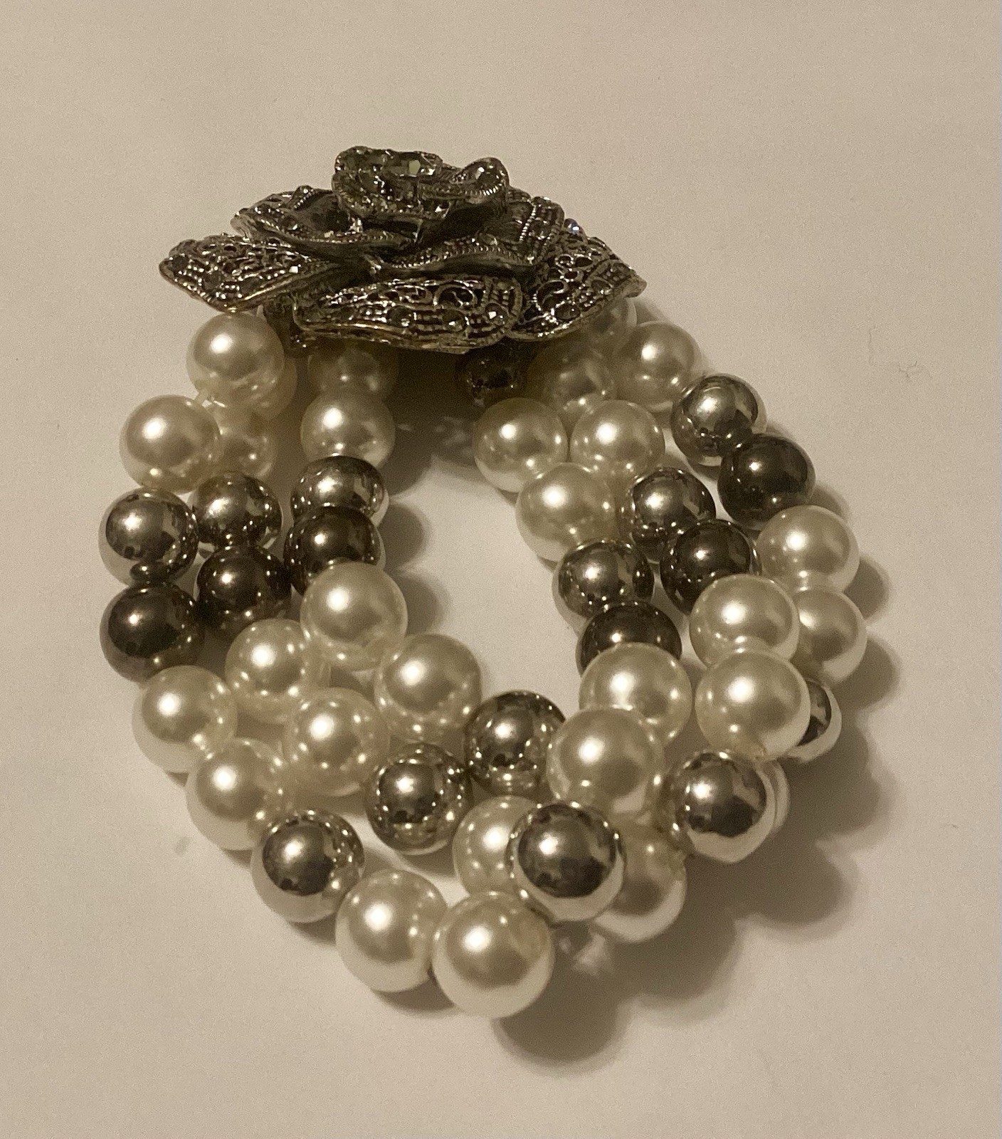 Three Strand Stretch Bracelet Featuring Faux Pearls With Large Flower Center