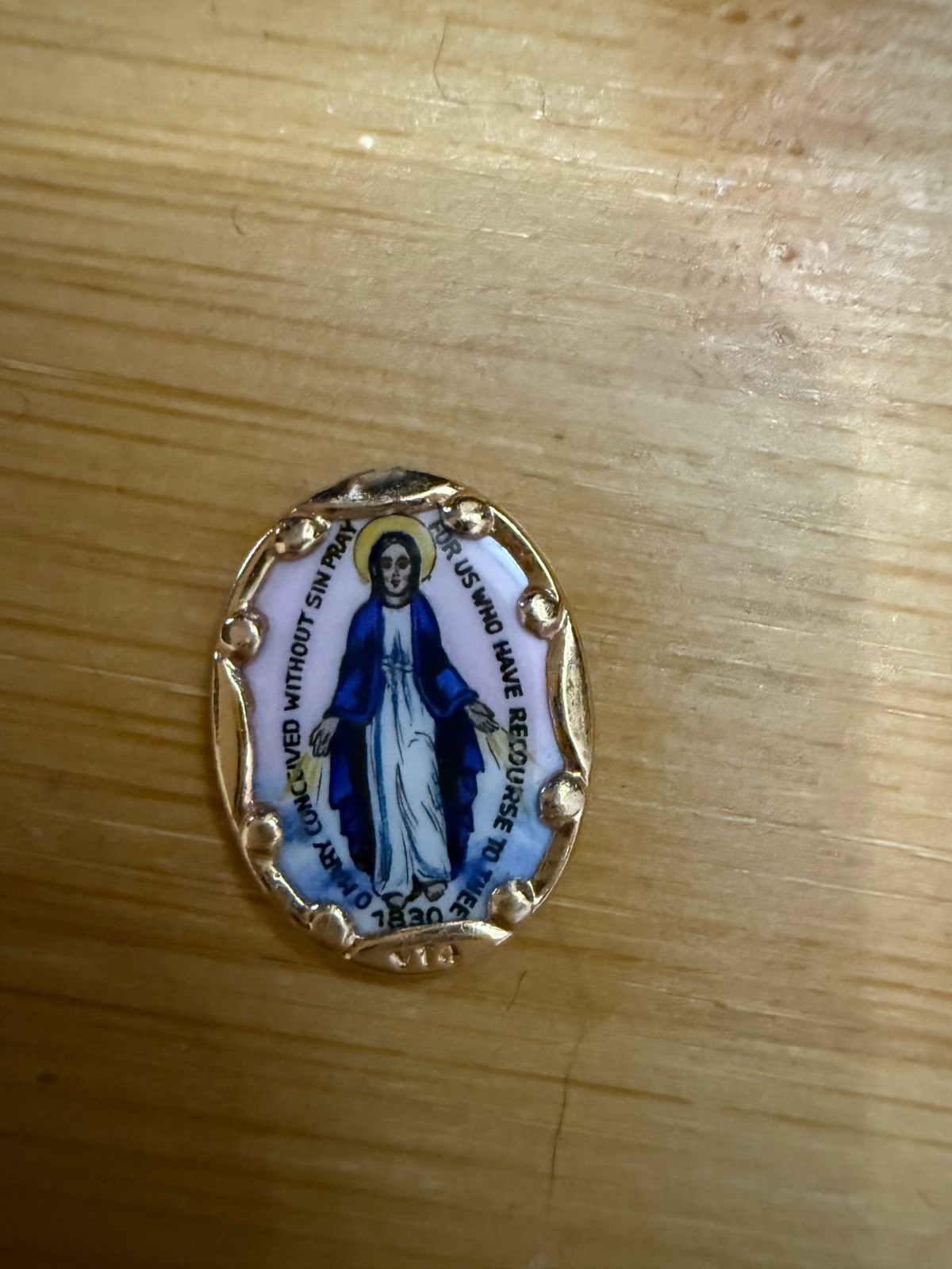 This 14K yellow gold Miraculous Medal features a hand-painted porcelain