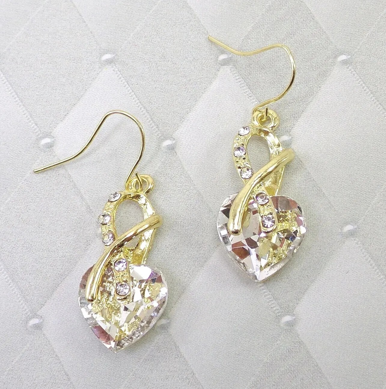 Clear crystal heart earrings in an aurora borealis finish gold wrap front New