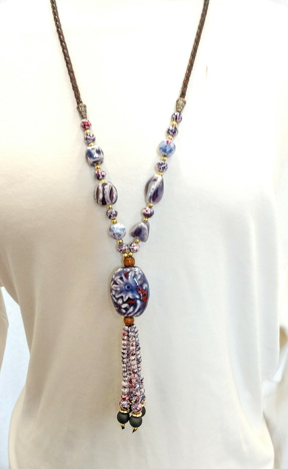 Purple ceramic beaded tassel necklace with wood beads attached to a leather cord