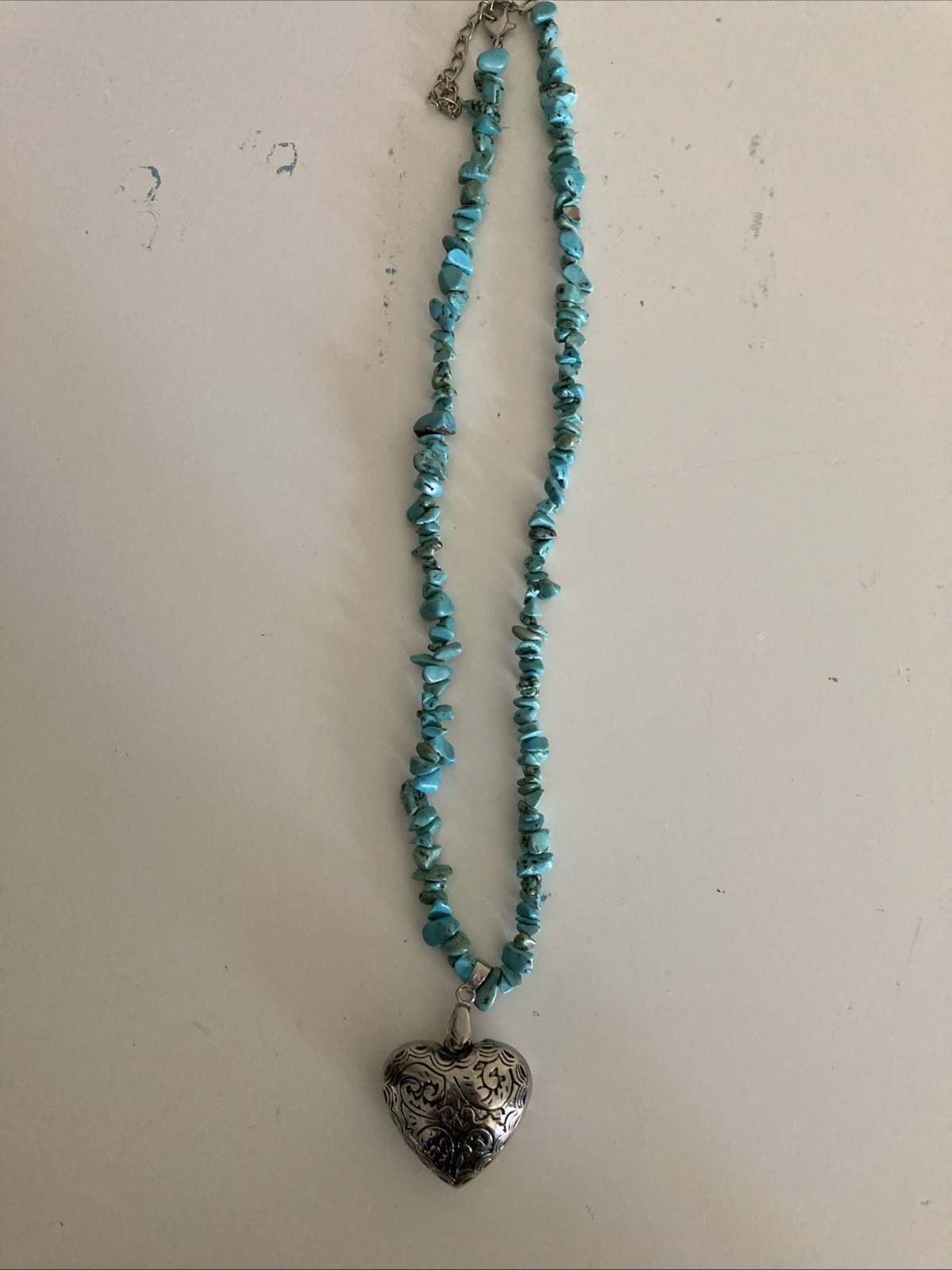 bohemian-style turquoise chip bead necklace with a large, textured heart pendant