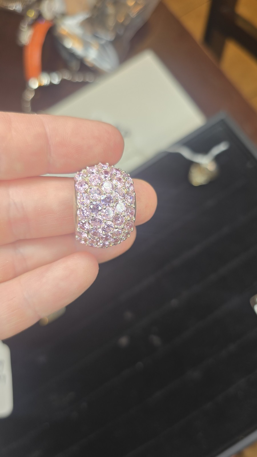 Wide Ring pavé setting of pink gemstones, likely sapphires or cubic zirconia
