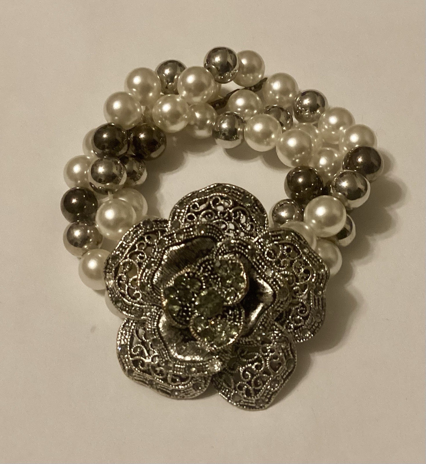 Three Strand Stretch Bracelet Featuring Faux Pearls With Large Flower Center