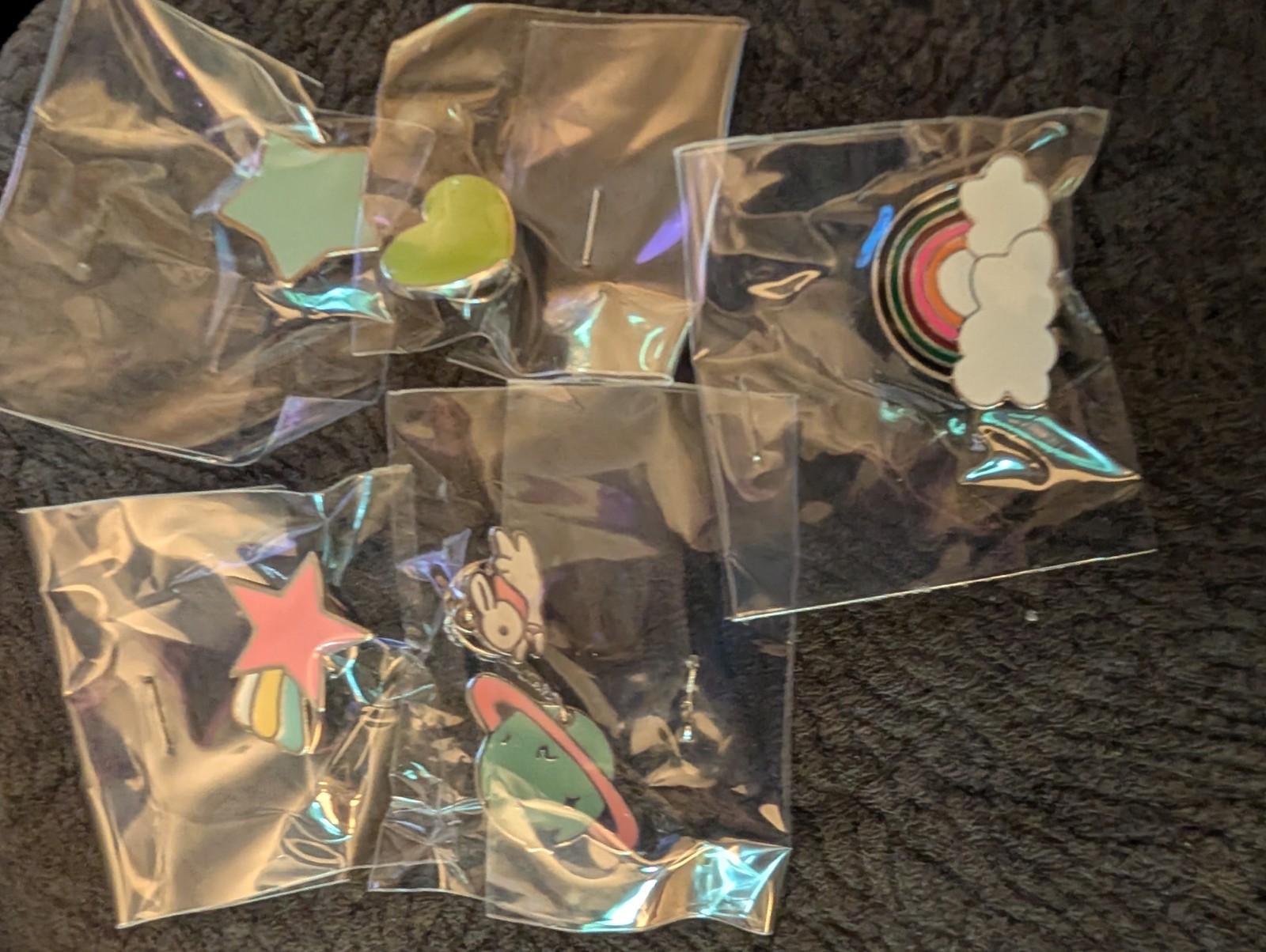 6 pins, 1 blue star, 1 pink star, 1 rainbow, 1 heart, 1 bunny, 1 universe pin
