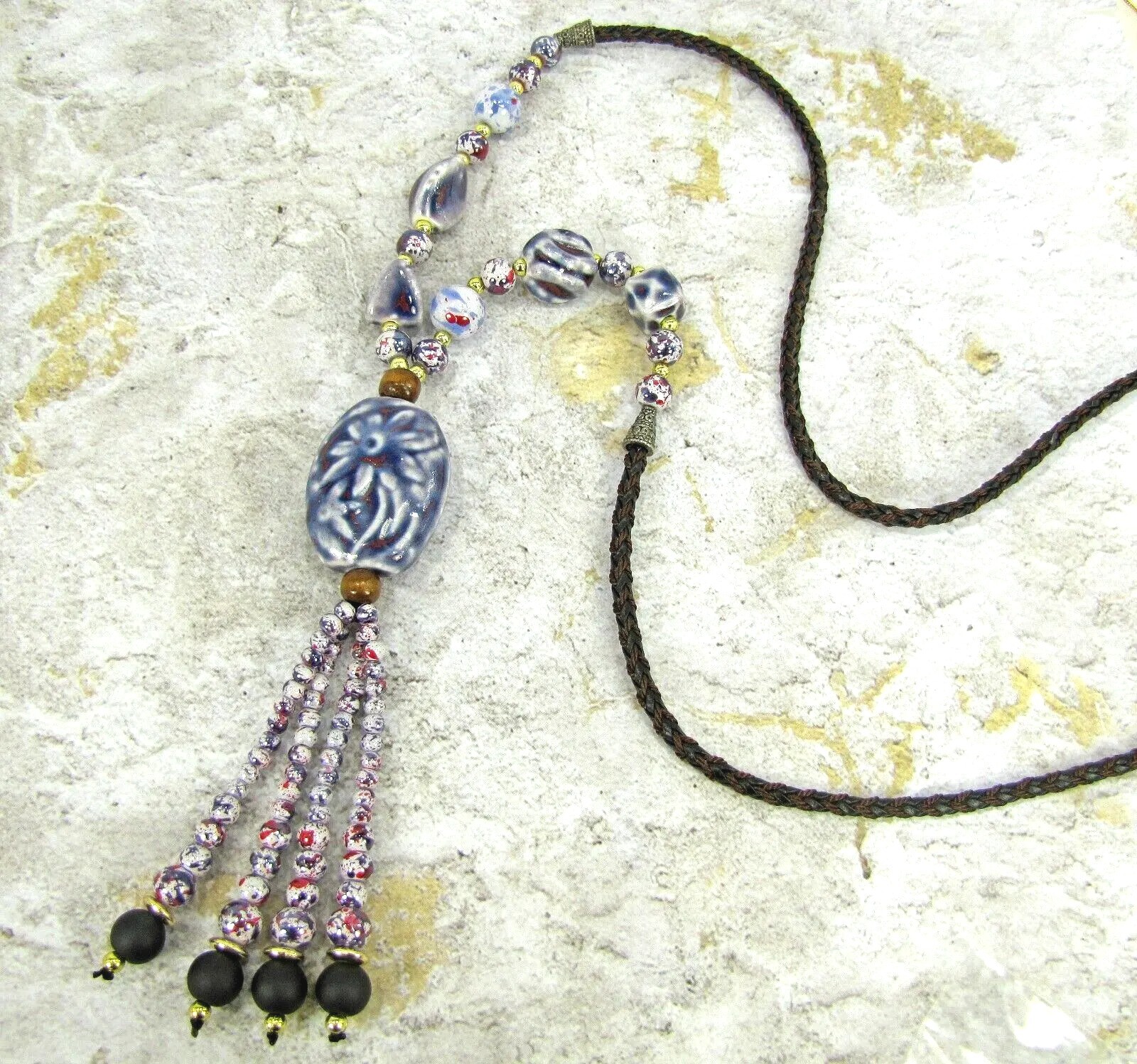 Purple ceramic beaded tassel necklace with wood beads attached to a leather cord