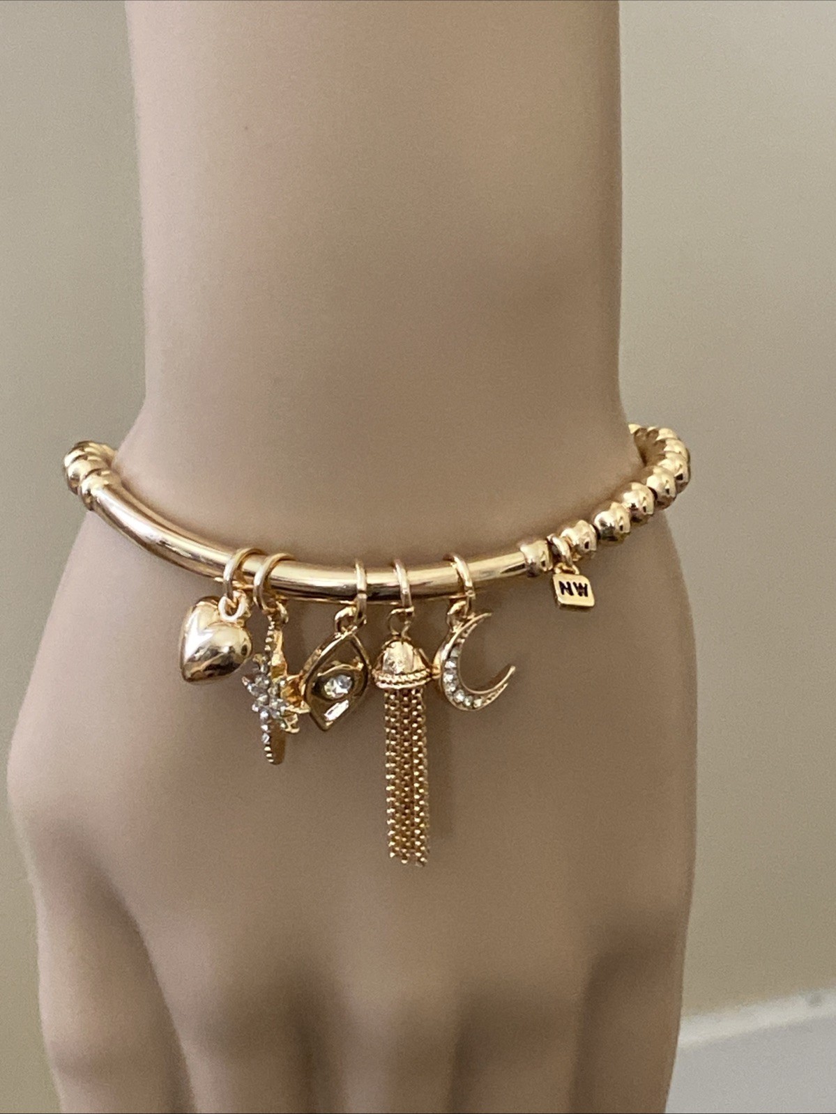 Nine West Gold Tone Tassel, Heart. Star, Moon, Evil Eye Charm Stretch Bracelet