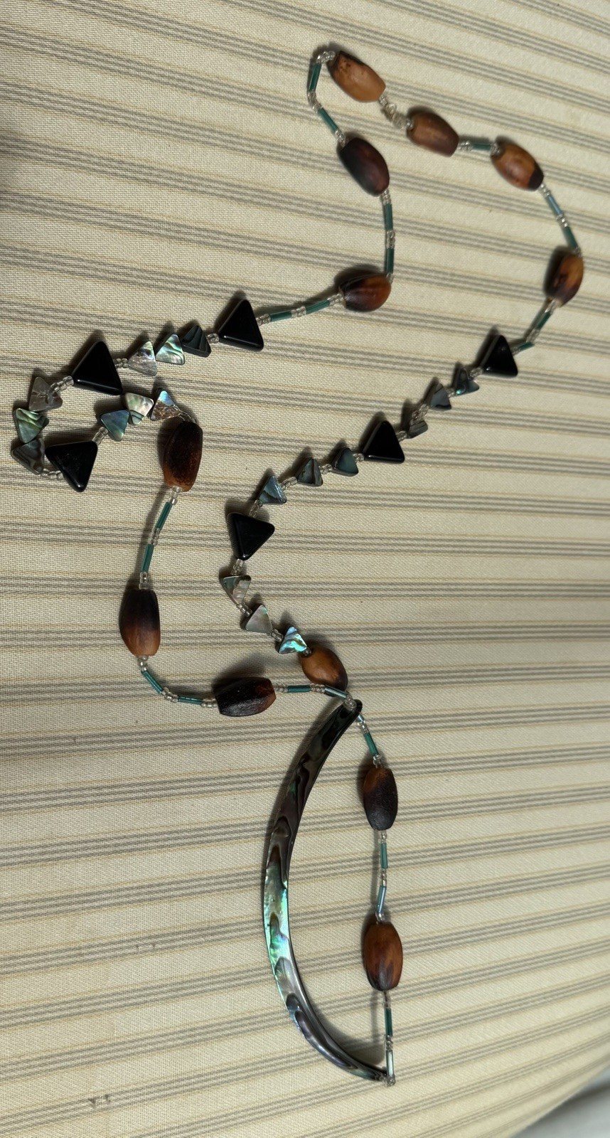 Handmade Hawaiian necklace featuring Koa seeds and abalone shell accents.