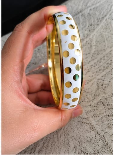 A modern and elegant bracelet set consisting of three white bracelets with gold