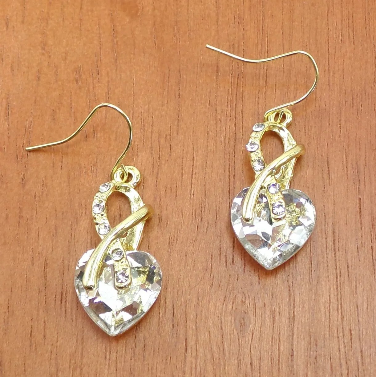 Clear crystal heart earrings in an aurora borealis finish gold wrap front New