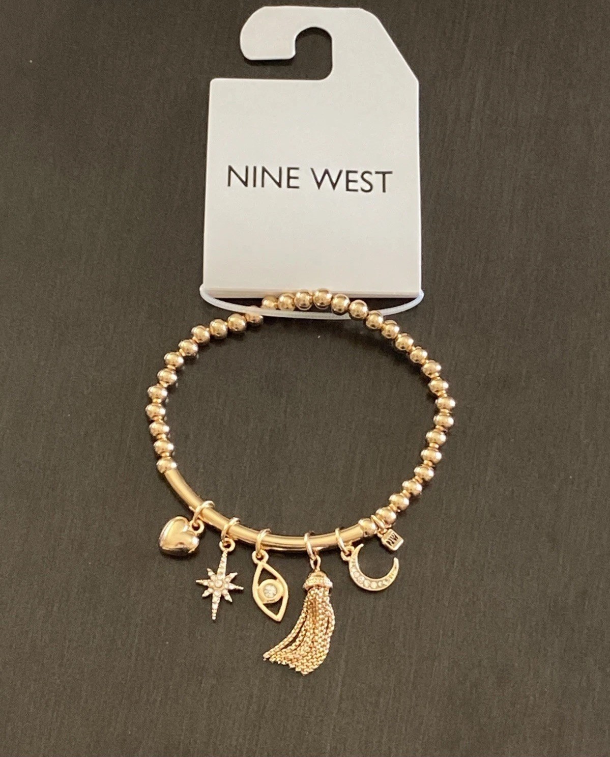 Nine West Gold Tone Tassel, Heart. Star, Moon, Evil Eye Charm Stretch Bracelet