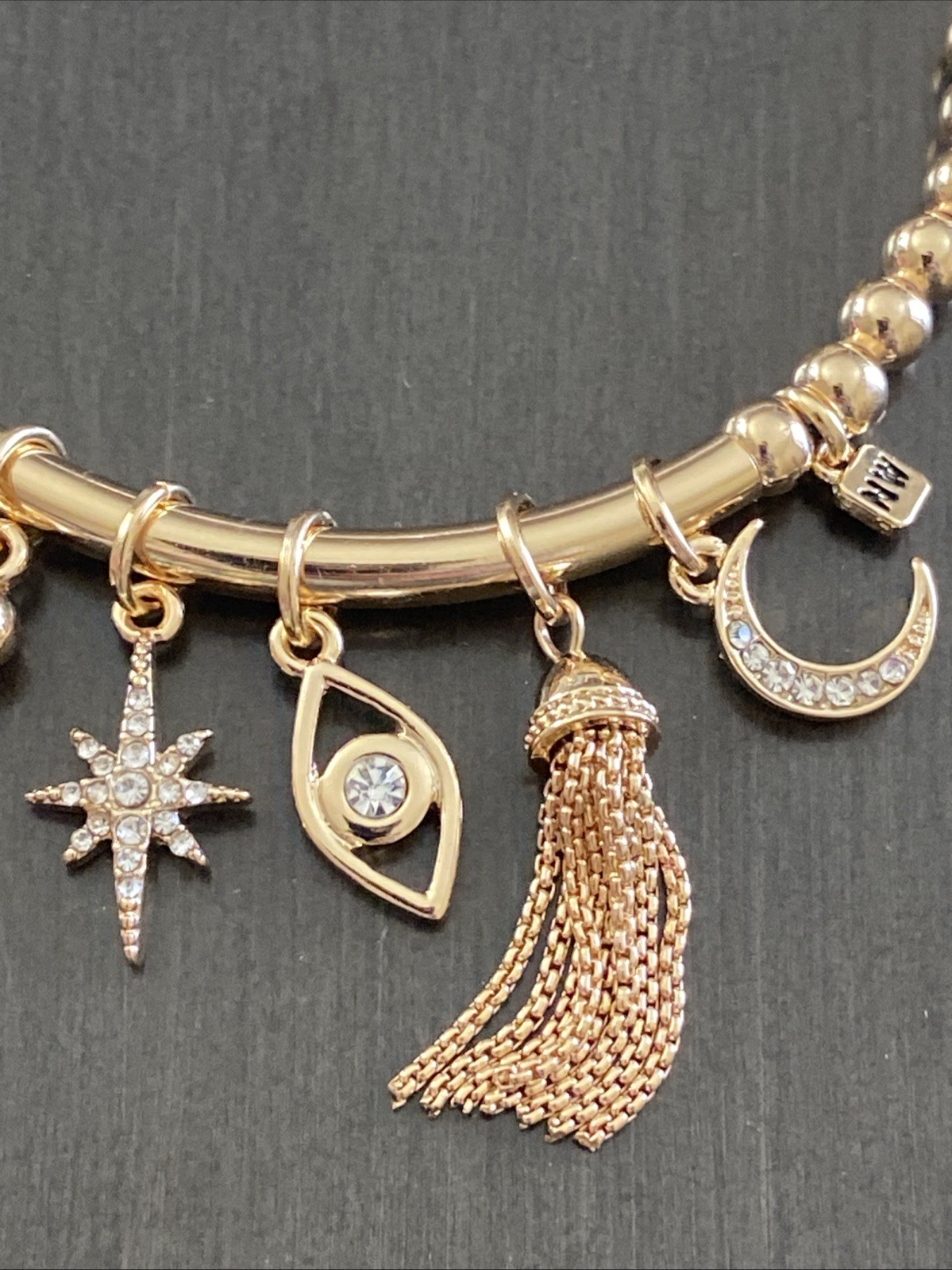 Nine West Gold Tone Tassel, Heart. Star, Moon, Evil Eye Charm Stretch Bracelet
