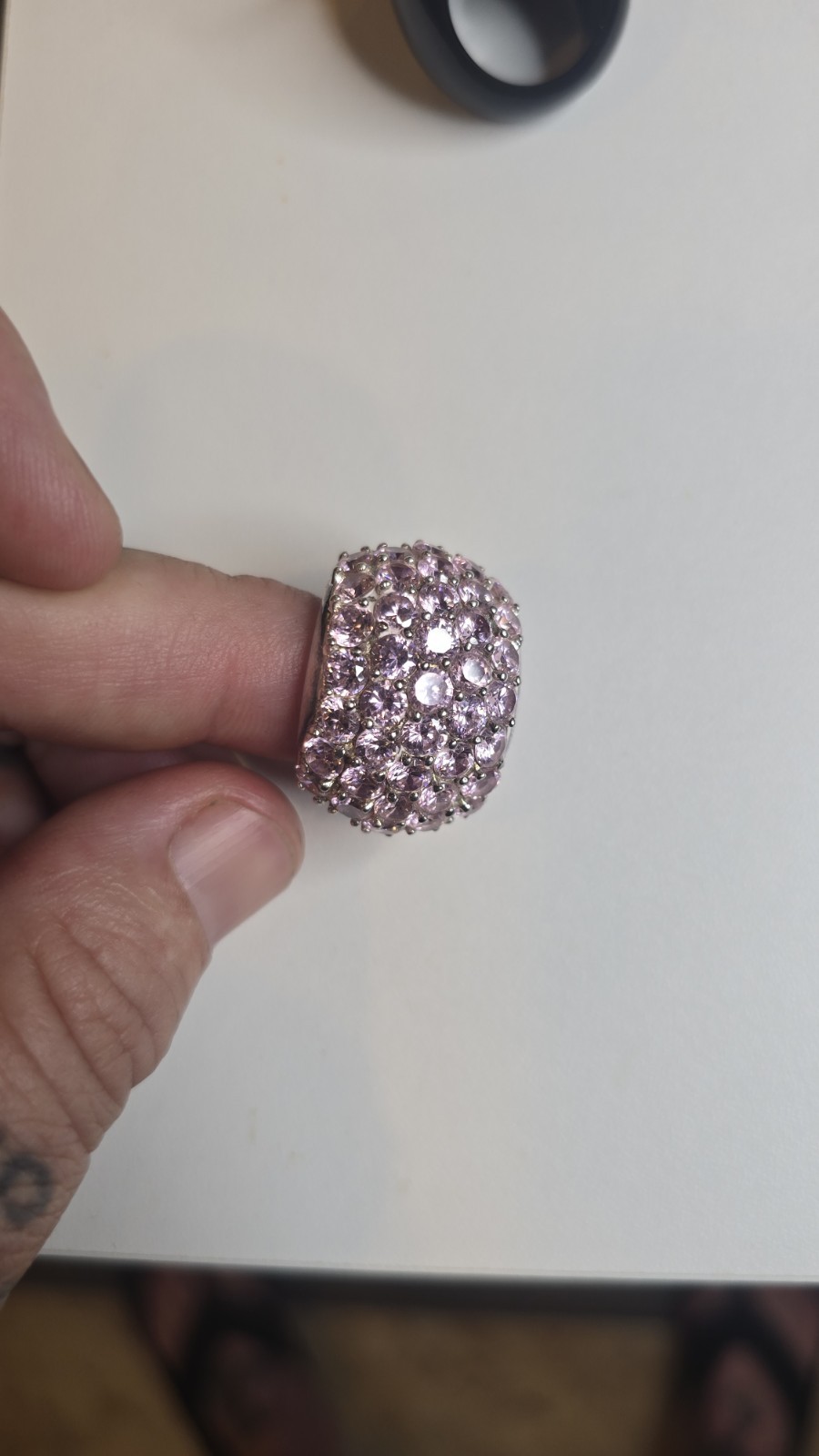Wide Ring pavé setting of pink gemstones, likely sapphires or cubic zirconia
