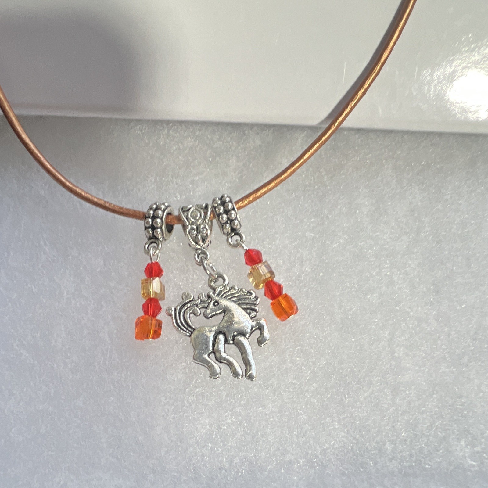 Prancing horse, orange crystals, bronze, leather cord, silver components,