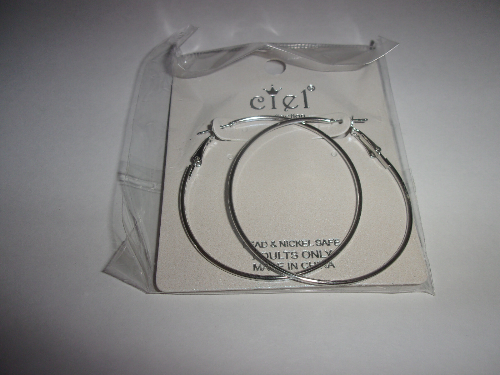 NEW IN PACKAGE, CIEL COLLECTION SILVERTONE HOOP EARRINGS APPROXIMATELY 2 1/8″