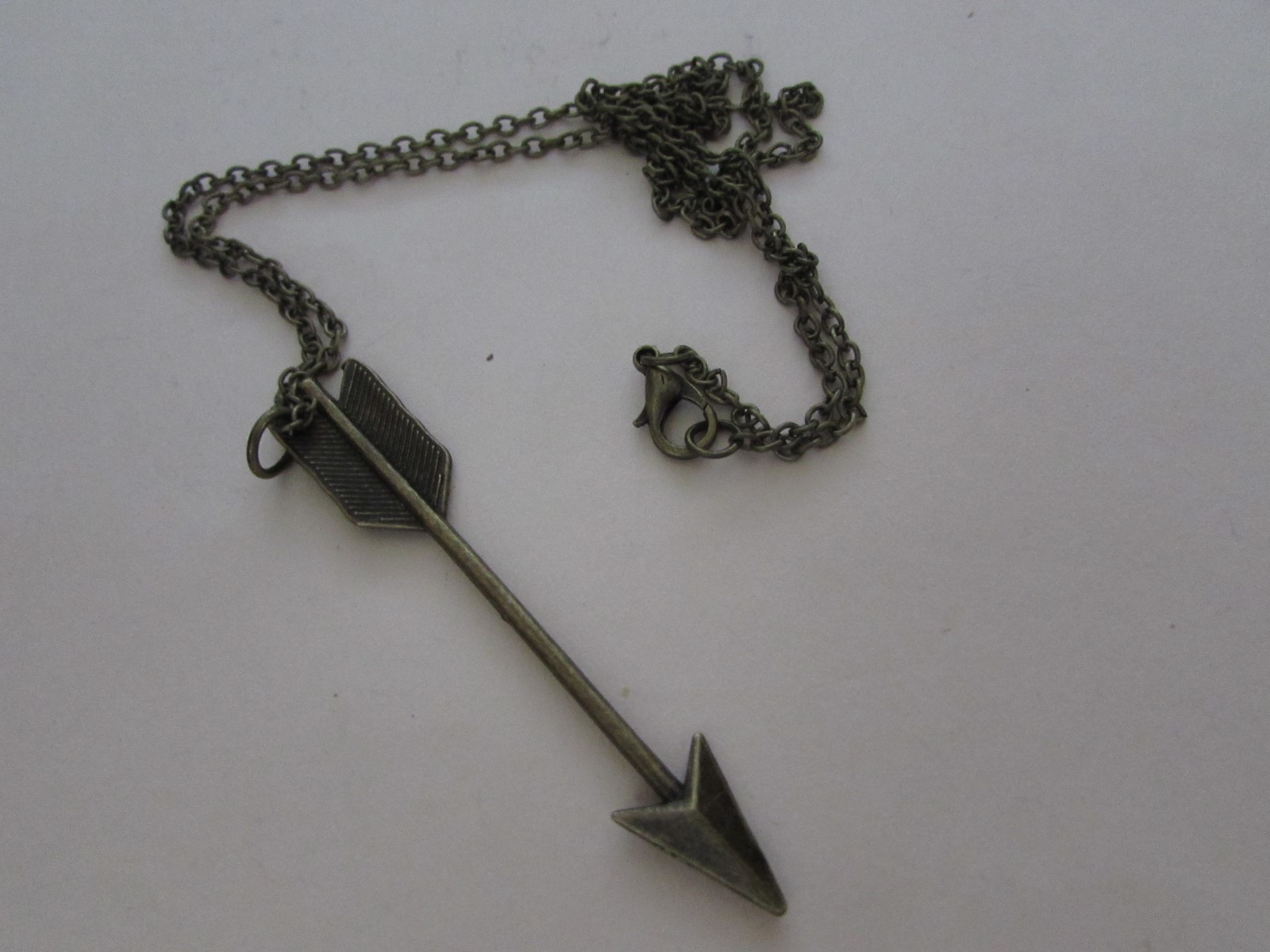 NEW/in pkg unworn Copper colored 24″ chain with 3″ copper arrow