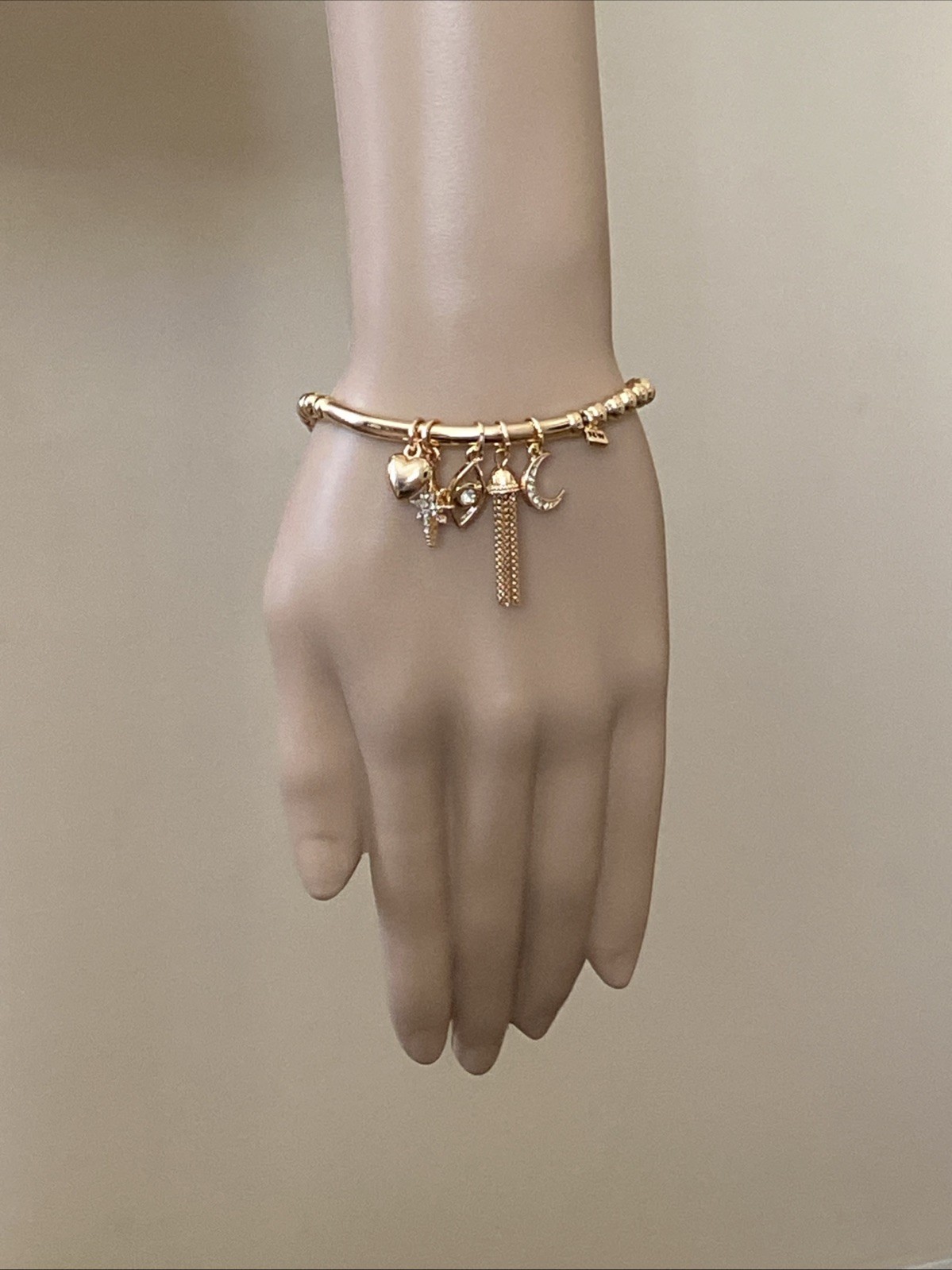 Nine West Gold Tone Tassel, Heart. Star, Moon, Evil Eye Charm Stretch Bracelet