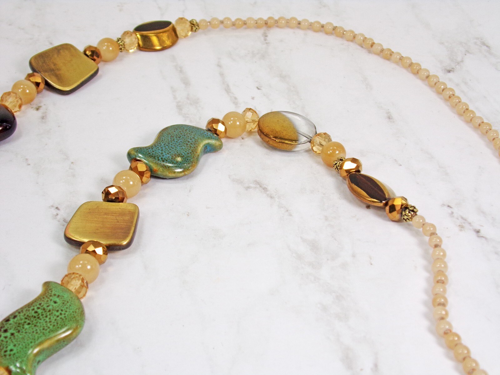 Multi color bead necklace with glass, ceramic, and metal beads, natural colors