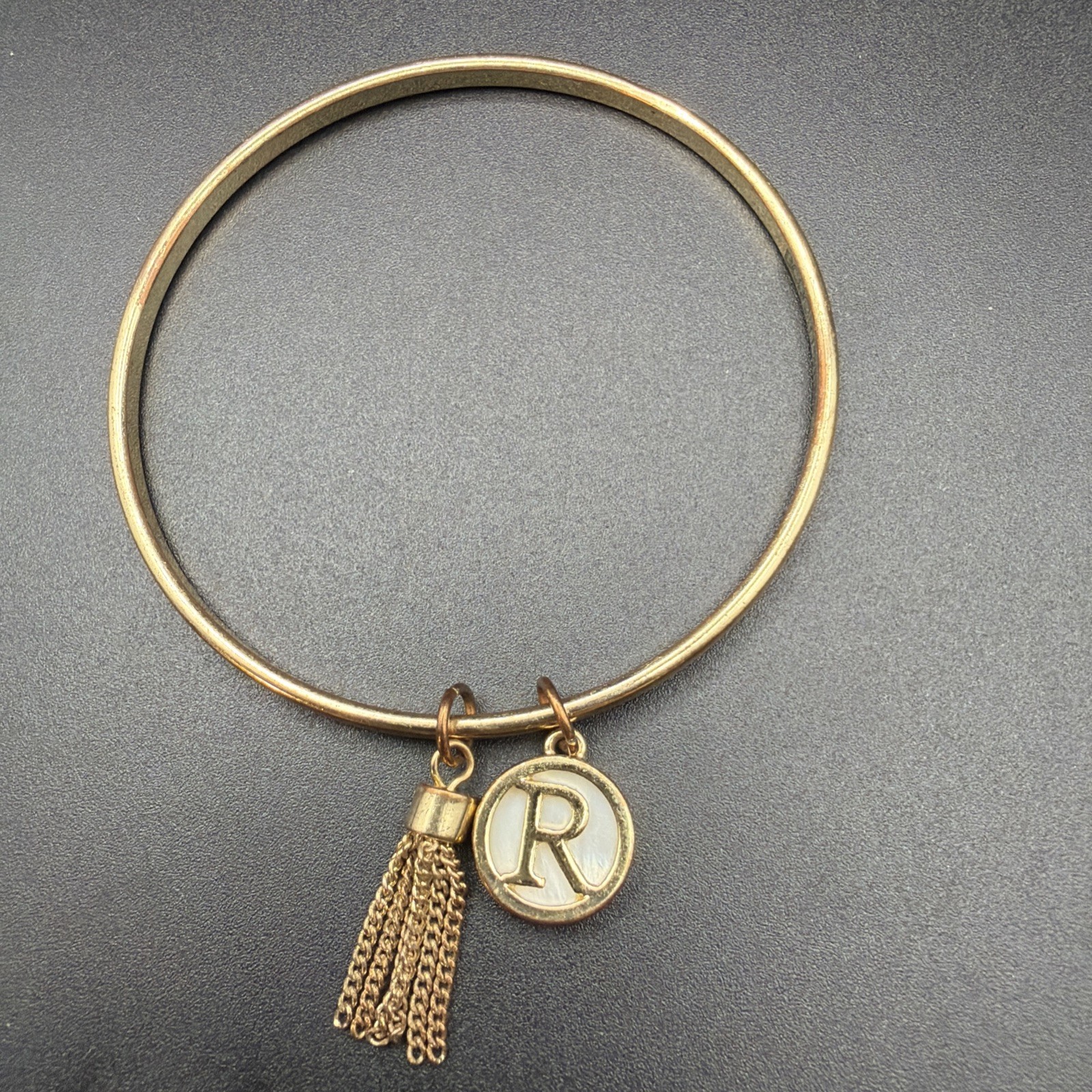 709. BCBGeneration “R” Bracelet With Tassle Gold Tone