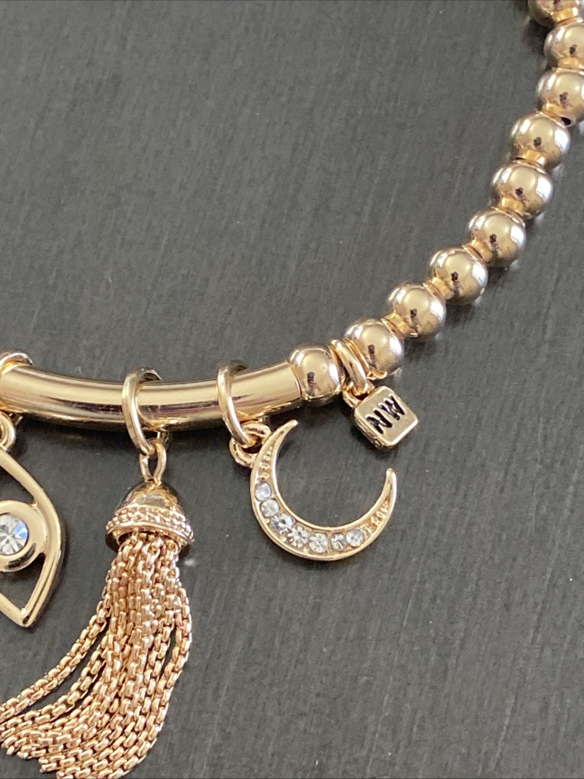 Nine West Gold Tone Tassel, Heart. Star, Moon, Evil Eye Charm Stretch Bracelet