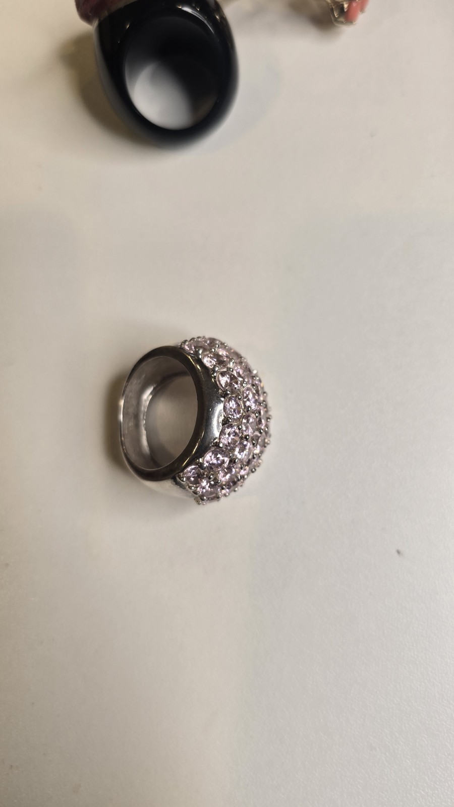 Wide Ring pavé setting of pink gemstones, likely sapphires or cubic zirconia