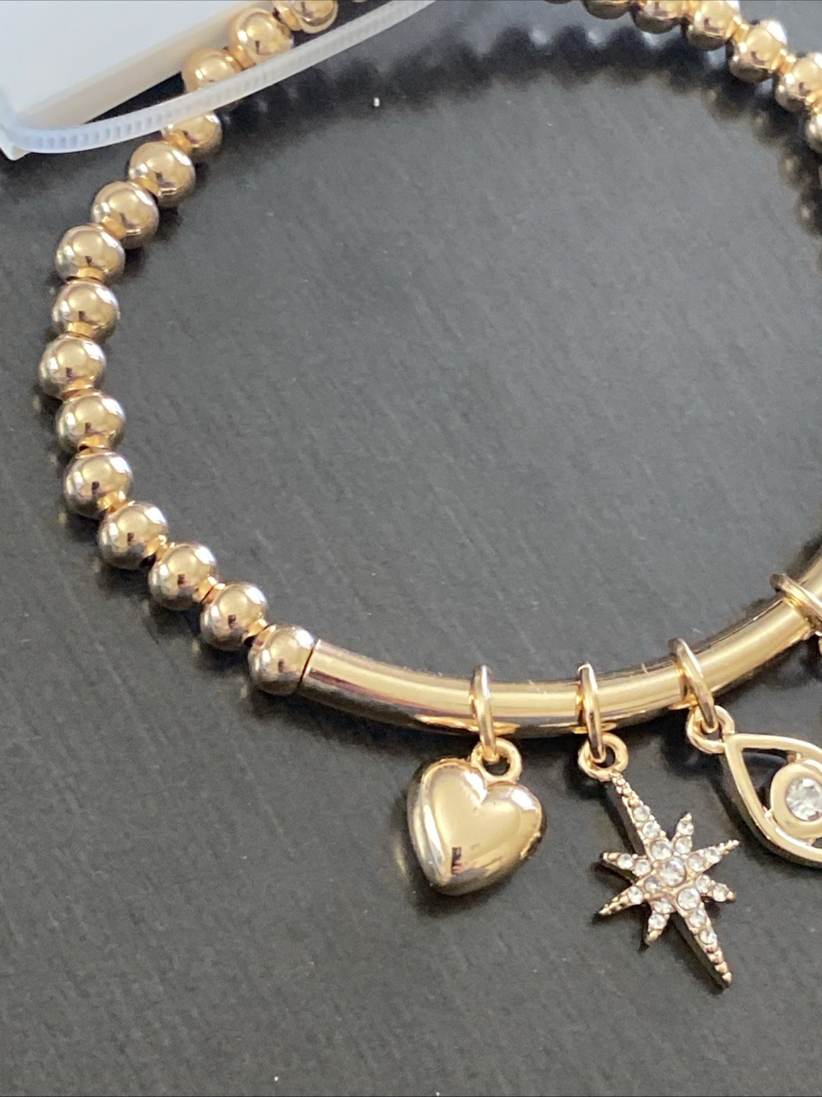 Nine West Gold Tone Tassel, Heart. Star, Moon, Evil Eye Charm Stretch Bracelet