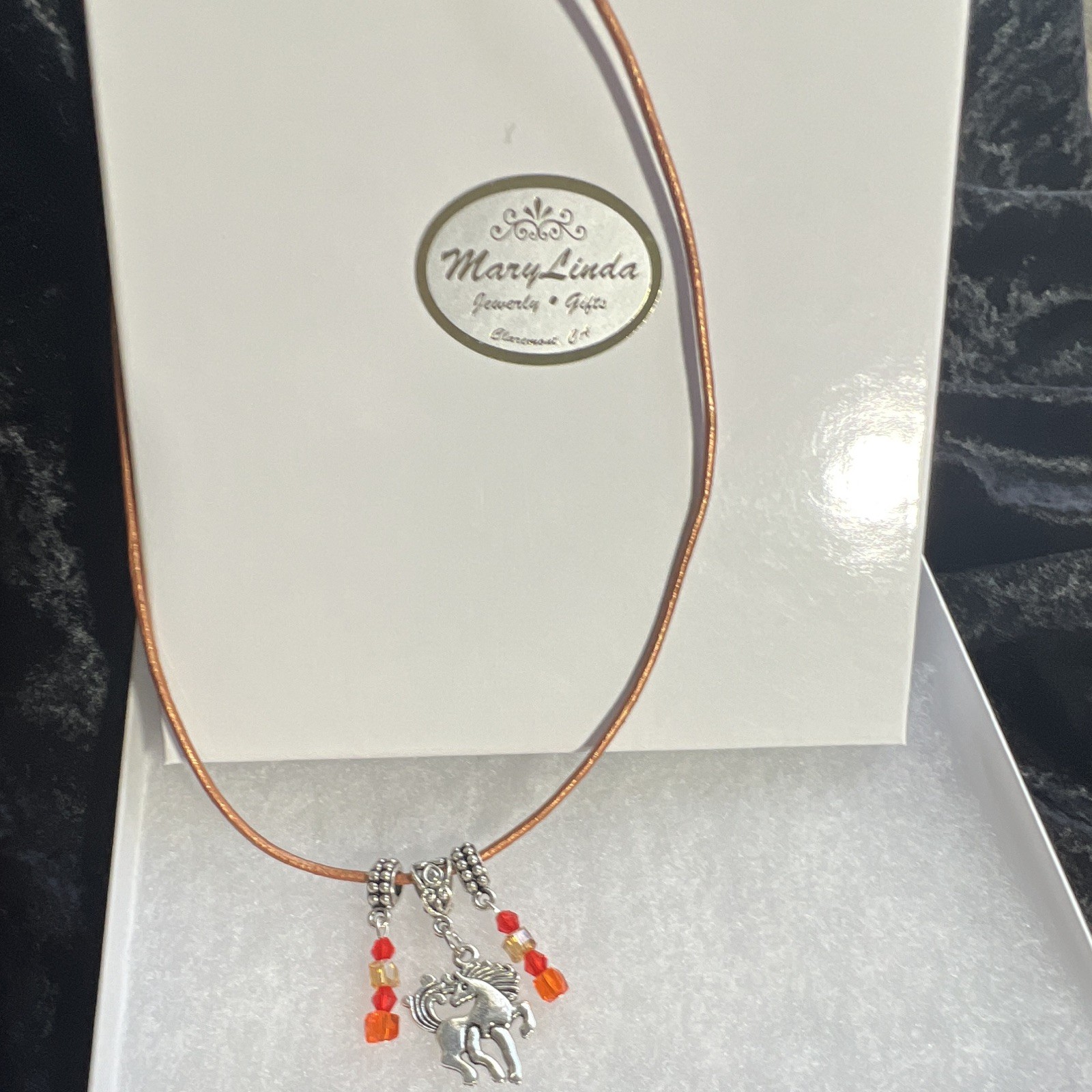 Prancing horse, orange crystals, bronze, leather cord, silver components,