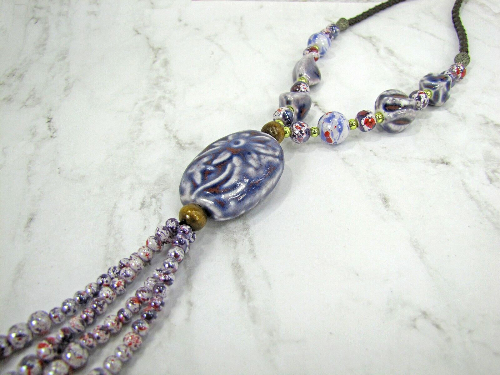 Purple ceramic beaded tassel necklace with wood beads attached to a leather cord